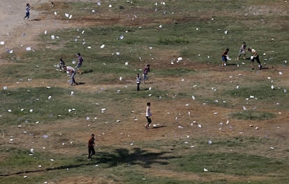 Varios palestinos recogen octavillas lanzadas desde un avión israelí en el barrio de Rimal, Ciudad de Gaza