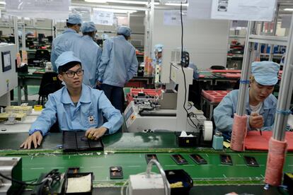 El estudio y los trabajos en recintos cerrados con luz artificial, en rápido auge en China, son considerados culpables de la epidemia de miopía en el país asiático. En la foto, jóvenes trabajadores en una fábrica de teléfonos móviles de Shenzhen.