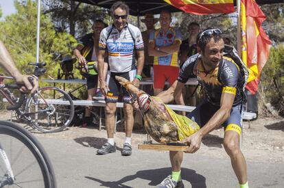 Un avituallamiento poco convencional. Miembros del Club Ciclista Xixona bromean ante el pelotón en el Xorret del Catí