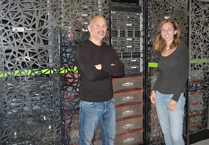 Sergi Beltrán y Leslie Matalonga posan frente al superordenador del Centro Nacional de Análisis Genómico (CNAG).