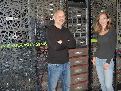 Sergi Beltrán y Leslie Matalonga posan frente al superordenador del Centro Nacional de Análisis Genómico (CNAG).