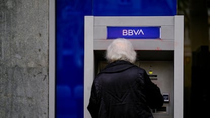 Una mujer saca dinero de un cajero del BBVA en Barcelona.