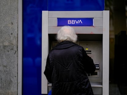 Una mujer saca dinero de un cajero del BBVA en Barcelona.