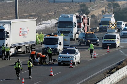Agentes de la Guardia Civil junto al cuerpo sin vida de uno de los conductores de tres camiones que han fallecido en la A6, en Tordesillas (Valladolid).