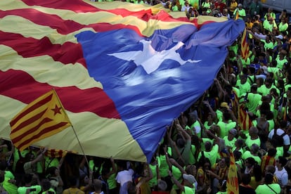 Una enorme bandera estelada es llevada por cientos de manifestantes.