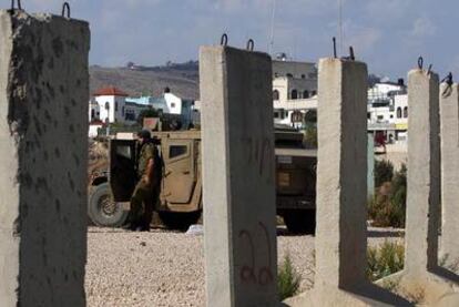 Un soldado israelí monta guardia tras unos pilares de hormigón, ayer en Ghajar.
