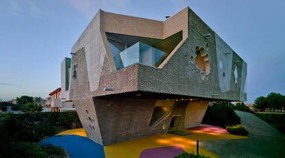 Esta vivienda se apoya en una base menor para ganar vistas y ceder espacio al jardín, de césped artificial y coloreado en tres tonos. El arquitecto Javier Peña asegura que la textura escamada del hormigón hará que la casa envejezca bien.