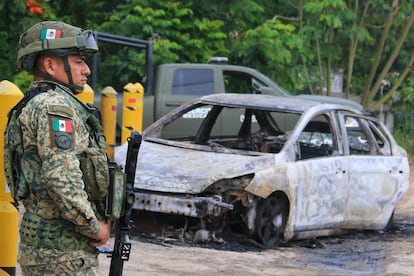 Un elemento del Ejrcito mexicano frente a un vehculo que fue incendiado tras la captura del lder del grupo criminal 'La Barredora', este martes en Villahermosa, Tabasco.