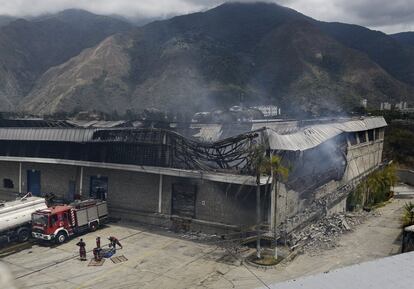 Los bomberos trabajan después de un incendio en un almacén del Consejo Nacional Electoral donde se destruyeron decenas de miles de máquinas de votación y lectores de huellas digitales, en Caracas (Venezuela).