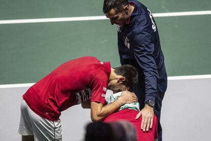 Djokovic y el capitán de serbia, Nenad Zimonjic, consuelan a Troicki tras la derrota ante Rusia en el encuentro de dobles.