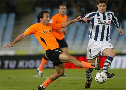 El jugador de la Real, Xabi Alonso, intenta controla el balón ante la entrada de Rufete.