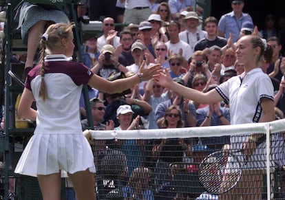 Las tenistas Jelena Dokic (i) y Martina Hingis se dan la mano tras el partido que ambas disputaron en Wimbledon el 22 de junio de 1999. En un resultado inesperado, Dokic ganó a Hingis por 6-2 y 6-0.  