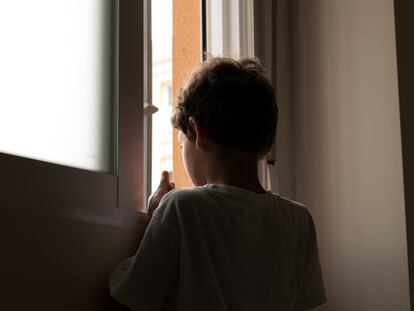 Un menor de edad se asoma a la ventana en una imagen de archivo.