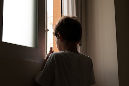 Un menor de edad se asoma a la ventana en una imagen de archivo.