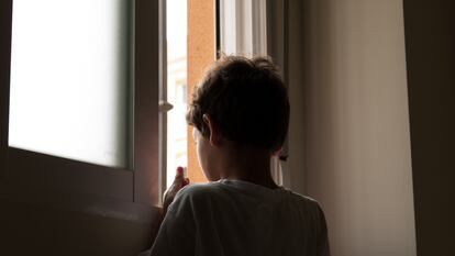 Un menor de edad se asoma a la ventana en una imagen de archivo.