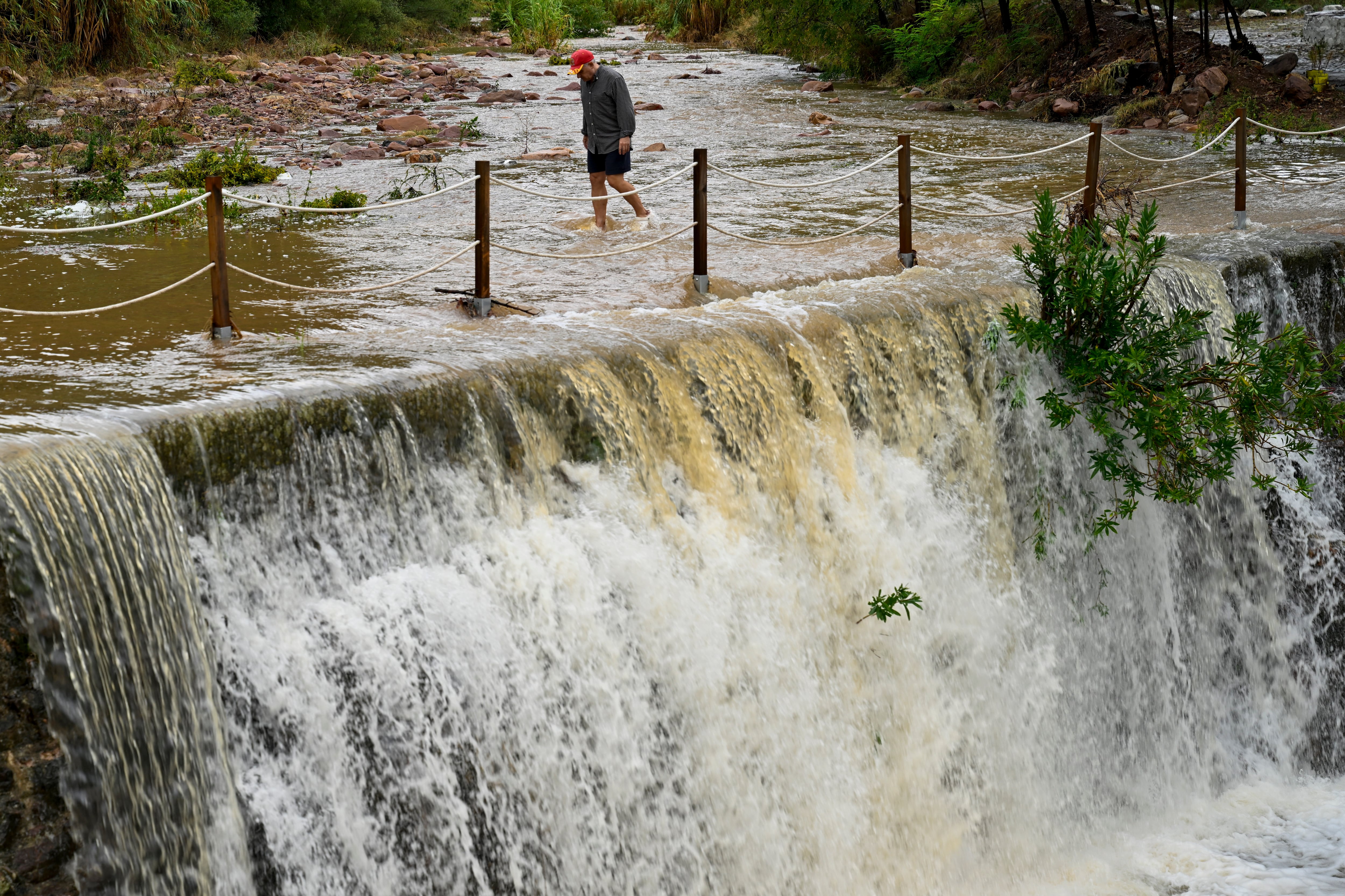 Un hombre cruza un badén inundable este lunes en Valencia. 