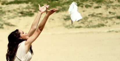 Una actriz en el papel de Virgen Vestal suelta una paloma blanca.