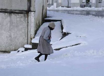 Una mujer en una calle de O Cádavo, en el municipio lucense de Baleira, que ayer quedó cubierto por la nieve.