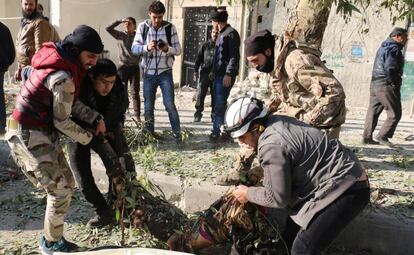 Rebeldes sirios transportan a una víctima de un bombardeo de las fuerzas del régimen de El Asad, este lunes en Alepo.