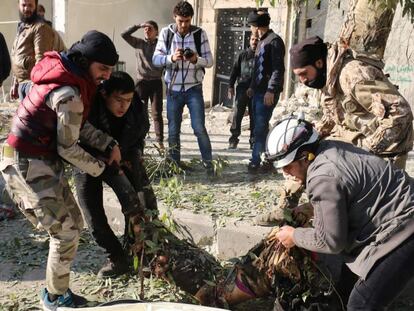 Rebeldes sirios transportan a una víctima de un bombardeo de las fuerzas del régimen de El Asad, este lunes en Alepo.