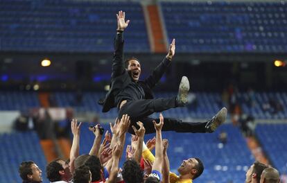 Simeone es manteado por sus jugadores.