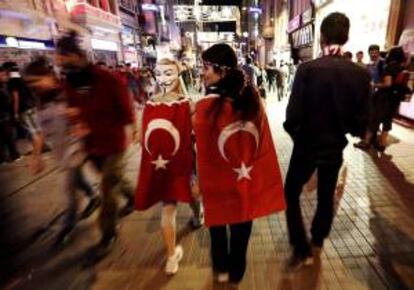 Jóvenes arropadas con banderas turcas caminan por la calle Istiklal ayer en la plaza de Taksim, en Estambul (Turquía).