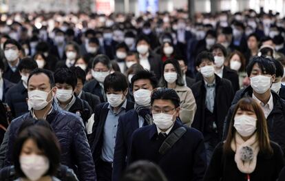 Trabajadores protegidos con mascarillas acuden a sus oficinas en Tokio este lunes