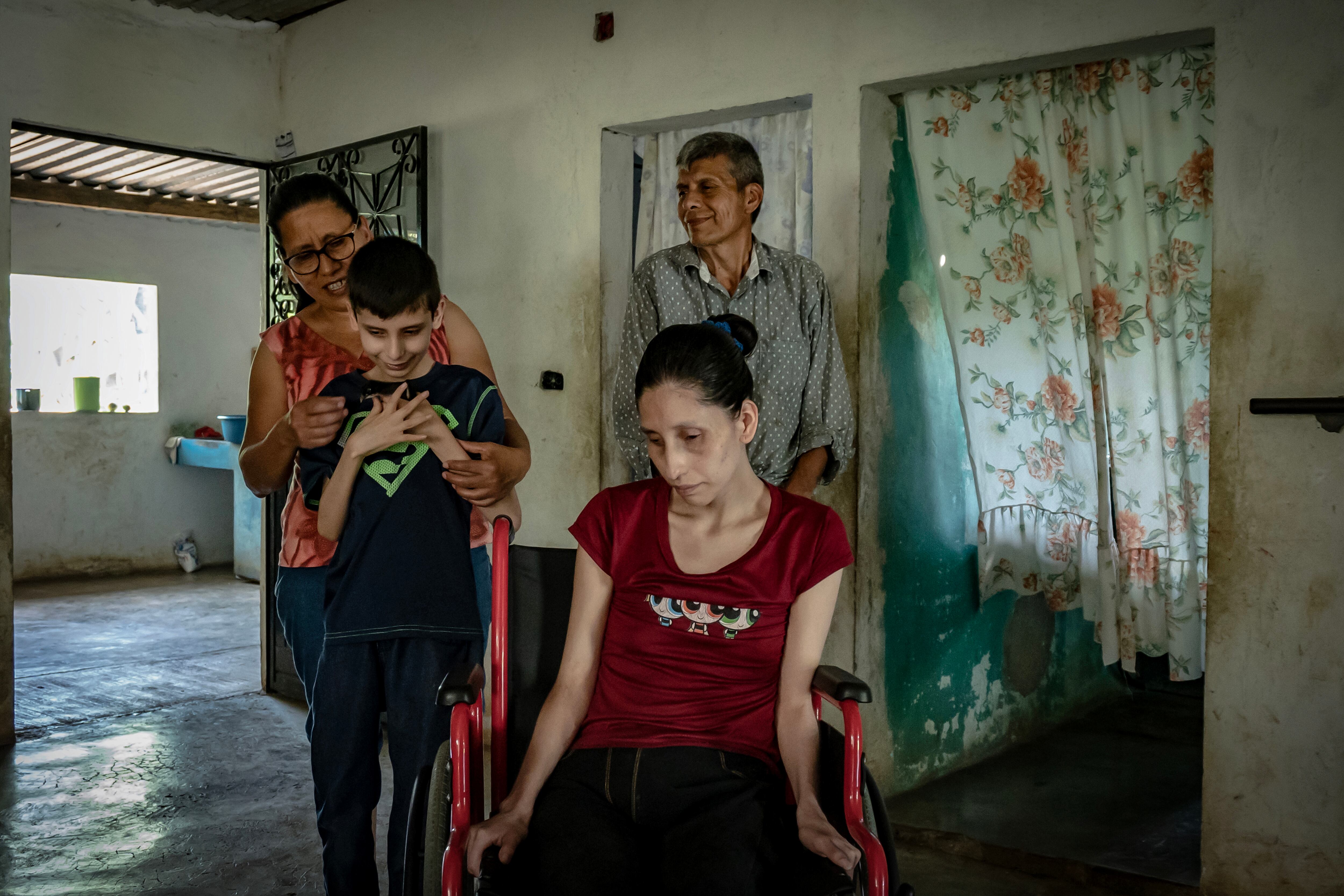 Félix Morales León, el pequeño Josué Medina Morales, Juan Medina Morales y Elizabeth Medina Morales se reúnen en el comedor de su hogar, en Tlaltetela, Veracruz, el 14 de junio de 2023. 

La ataxia tipo 7,  es un trastorno hereditario con una prevalencia de 1 entre 100.000, es decir, se trata de una enfermedad muy rara. No obstante, en México se encuentra la población más amplía de personas que viven con esta enfermedad neurodegenerativa para la que no hay cura.  En Tlaltetela, Veracruz, un municipio conformado por comunidades campesinas dedicadas a la producción de café, caña y limón persa, este devastador padecimiento afecta a 200 personas, de las 6000 que existen en el poblado.   Josué, Juan y Elizabeth fueron diagnosticados con ataxia 7, y actualmente el único que puede continuar trabajando como campesino. 
