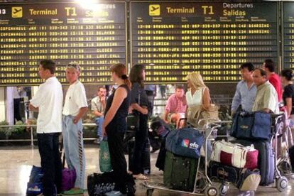 Pasajeros esperan subir a sus aviones en el aeropuerto de Madrid Barajas