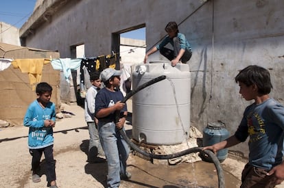 Varios ni&ntilde;os se coordinan para llenar los dep&oacute;sitos del agua que traen camiones cisternas cada ma&ntilde;ana. Este agua deben pagarla, al igual que las tiendas o el alquiler de las tierras donde se han instalado. Asentamiento de Fayda 15, Zahle, L&iacute;bano.