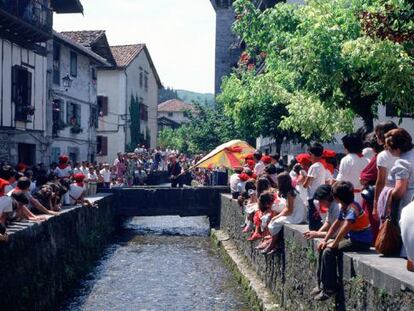 La bandera ondea sobre el río Onín durante las fiestas de San Fermín en Lesaka (Navarra).