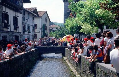 La bandera ondea sobre el río Onín durante las fiestas de San Fermín en Lesaka (Navarra).