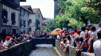La bandera ondea sobre el río Onín durante las fiestas de San Fermín en Lesaka (Navarra).