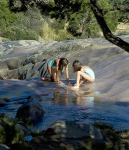 Dos niñas juegan en Charca Verde de La Pedriza.