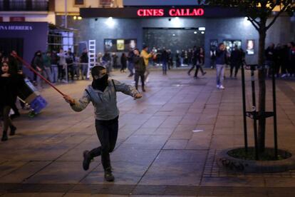 Un manifestante lanza un palo contra la policía en la plaza de Callao de Madrid.