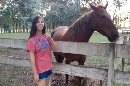 Lucila, 13 años, tiene un TEA y posa con un caballo.