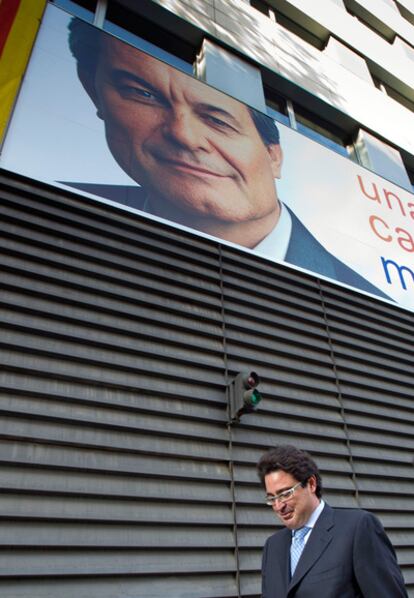 David Madí pasa delante de un cartel electoral de Artur Mas.