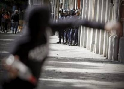 Unos antidisturbios observan los movimentos de un joven en una manifestación. EFE/Archivo