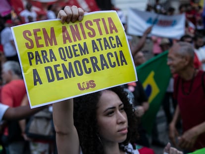 Una mujer sostiene un cartel con un mensaje que dice: "No hay amnistía para los que atacan la democracia", en una manifestación en Río de Janeiro, Brasil, en enero de 2024.