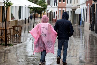 Dos personas caminan bajo la lluvia por las calles de Es Mercadal (Menorca) este lunes.