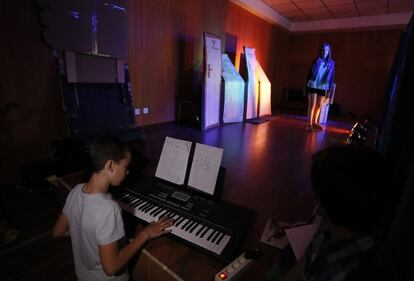 Fernando toca el piano mientras su compañera Érika canta en el ensayo de la función.