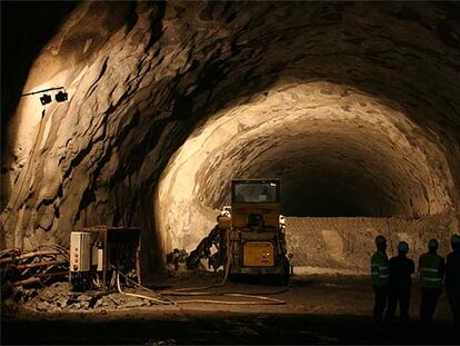 A la derecha, un grupo de personas observa el tercer túnel de Guadarrama.