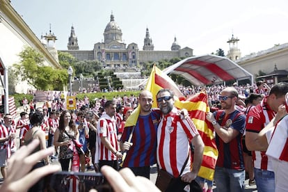 Un aficionado azulgrana y otro rojiblanco posan para una foto en el punto de encuentro en las fuentes de Montjuic.