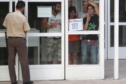 Los profesores encerrados en la Dirección de Área Territorial de la Consejería de Educación, junto a un guardia de seguridad.