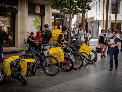 Varios 'riders' con mochilas de Glovo, en Sevilla el 15 de mayo.