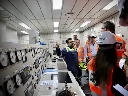 A sailor explains how the engine room of a ship works to a group of visitors in Malaysia, in February 2023.