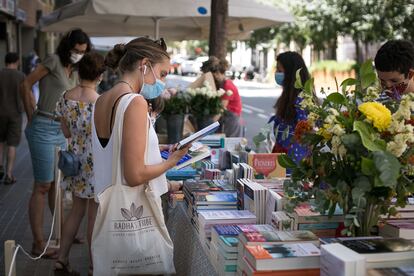 Una compradora, ante uno de los pocos puestos callejeros en el Sant Jordi de este jueves en Barcelona.