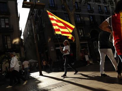 Dos mujeres con una bandera de España y otra de Cataluña.