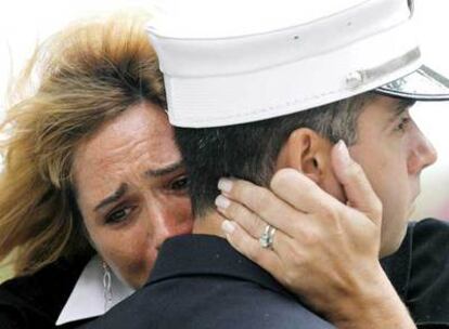 Una mujer llora abrazada a un bombero en Nueva York, durante la ceremonia por el sexto aniversario del 11-S.
