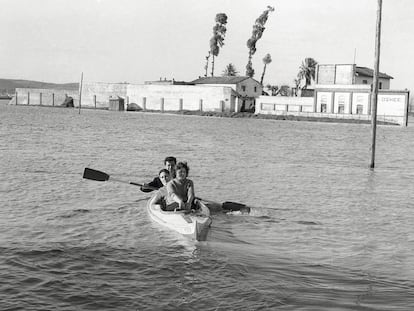 Tres personas navegan en piragua por la sevilla inundada de 1961.